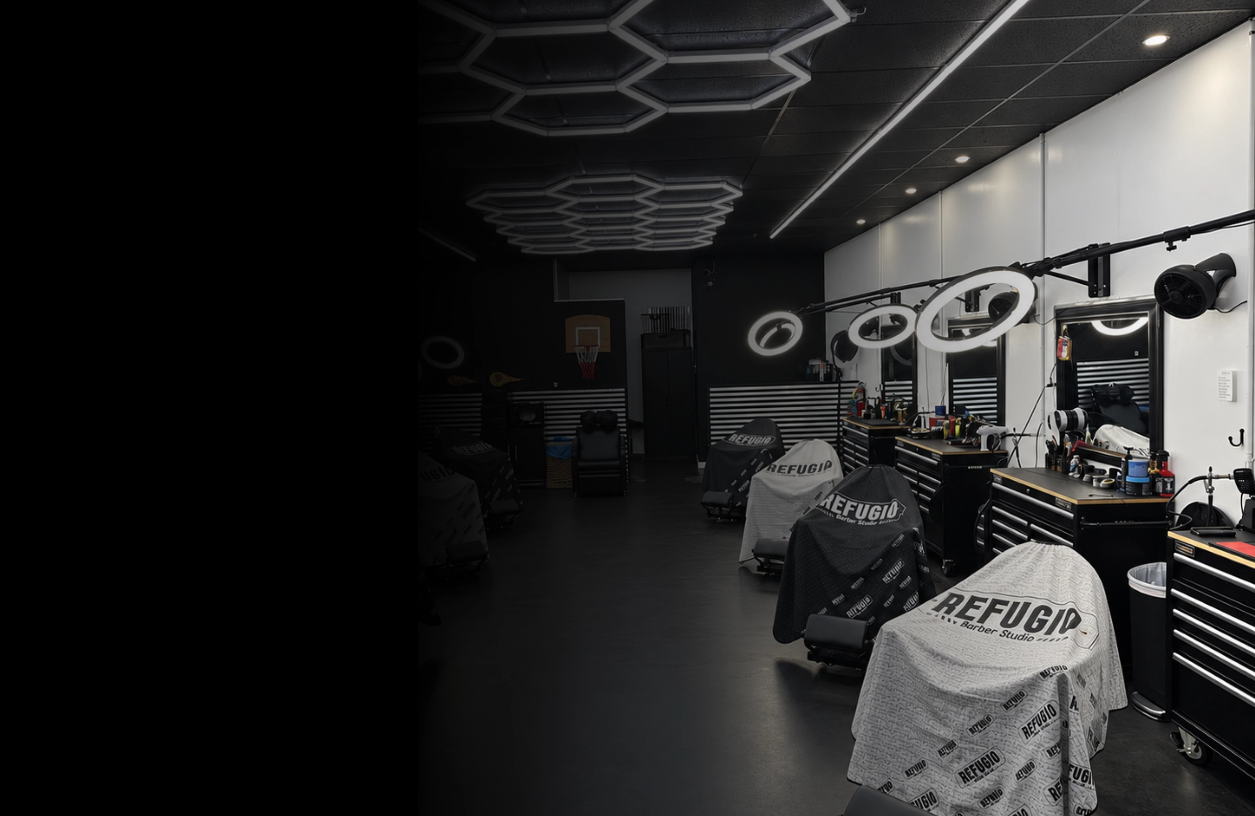 Inside Refugio Barber Studio: chairs under the brand’s capes and hexagonal lights on the ceiling